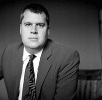 A man in a suit and tie sitting down.