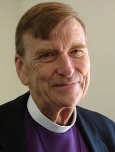 A close up of an older man wearing a priest 's collar